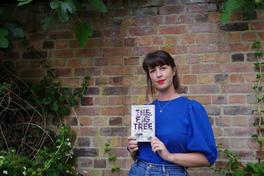 A photograph of translator Olivia Hellewell holding a copy of The Fig Tree