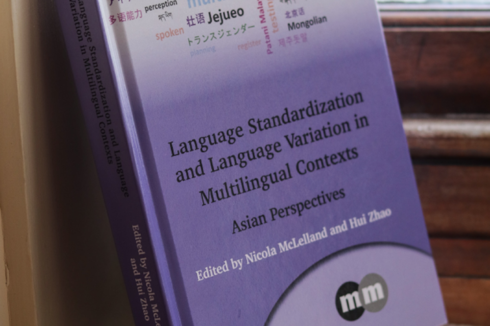 Language standardisation book leaning against window frame