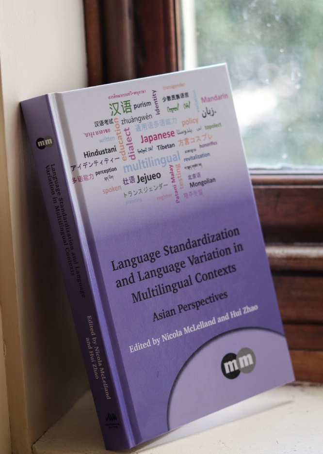 A copy of Language Standardization and Language Variation in Multilingual Contexts resting on a windowsill.