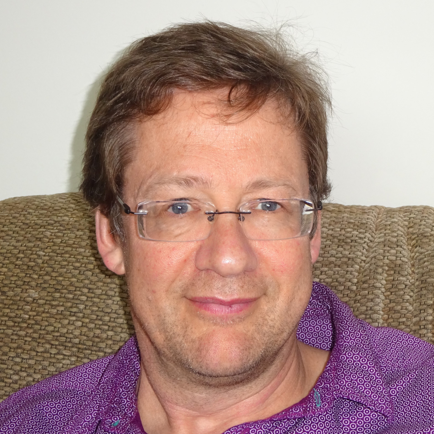 Headshot of Philip wearing glasses and purple shirt