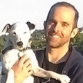 Headshot of Zach Hoskins holding a white dog