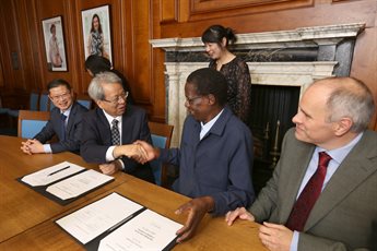 CICO delegates and University of Nottingham representatives shake hands as they sign the Memorandum of Understanding in a wood-panelled boardroom