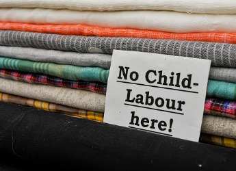 A pile of cloth with sign saying no child labour here