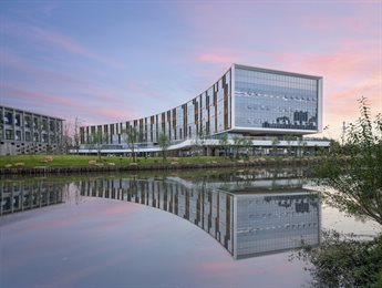 Nottingham University Business school, Ningbo, China campus at dusk, with the building reflection seen in the lake. 