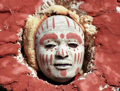 A white and red painted mask on face.