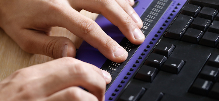 Close up view of someone using a braille keyboard