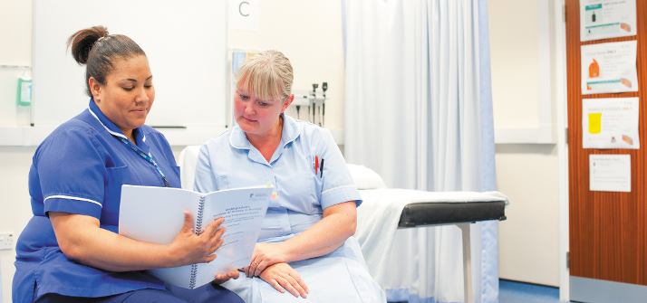 A nurse and student nurse looking at a document