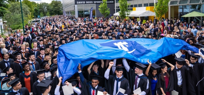 Graduating students with the university flag