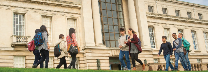 Undergraduate students walking and relaxing outside Portland building 714x249