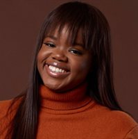 Headshot photo of Deborah Igunma, smiling in front of a brown background