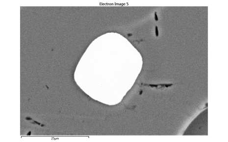 A rounded zircon crystal trapped in one of the Must Farm glass beads. Zircons are one of the minerals that occurs in sands
