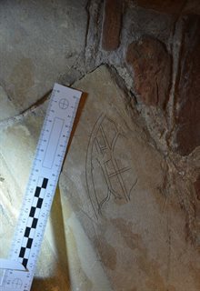 Partially completed carved drawing of a medieval window in a stone floor, with a ruler next to it to measure the size (approx. 11")