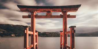 A Japanese style arch on a lake on a cloudy day
