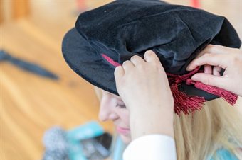 Student fixing their mortarboard during graduation