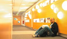 Male student reading in Hallward Library corridor