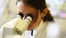 Image of a female student using a Microscope in a lab