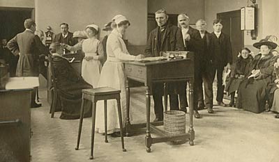 Photograph from 1912 showing nurses, doctors and patients in the Outpatients Consulting Room