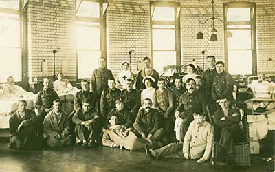 Group photograph of soldiers and nurses in a hospital ward