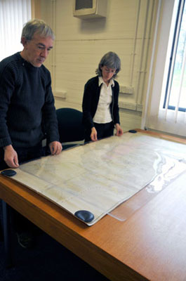 Placing a polyester protective sheet over a large map
