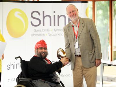 Prof Roger Bayston receiving the Lifetime Contribution Award from Amar Dugal, Board Director of Shine Charity