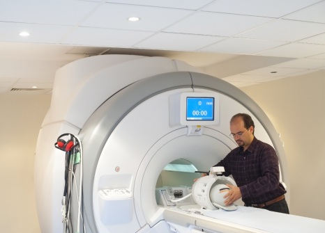 Male postgraduate student working on an MRI scanner