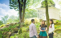 Male and female postgraduate students talking at the Summer House, University Park Campus