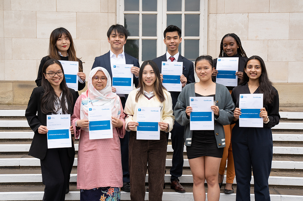 A group of undergraduate scholars from various countries standing with scholarship certificates at an international scholarships celebration