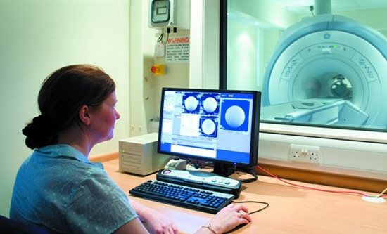 Female health worker operating an MRI scanner