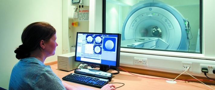 female radiographer operating an MRI scanner