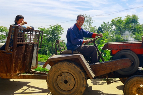 Chinese farmer riding a tractor.