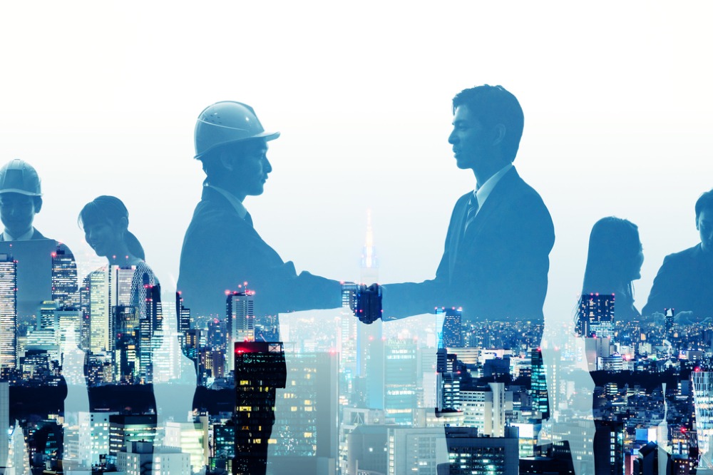 An image of a workman shaking hands with an office worker