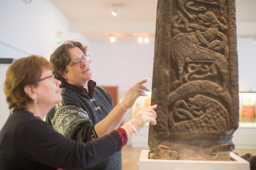 Two staff members examining a medieval exhibit