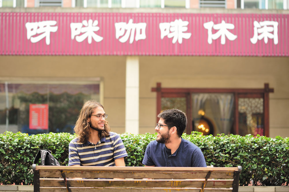 Two male students sitting on a bench in China