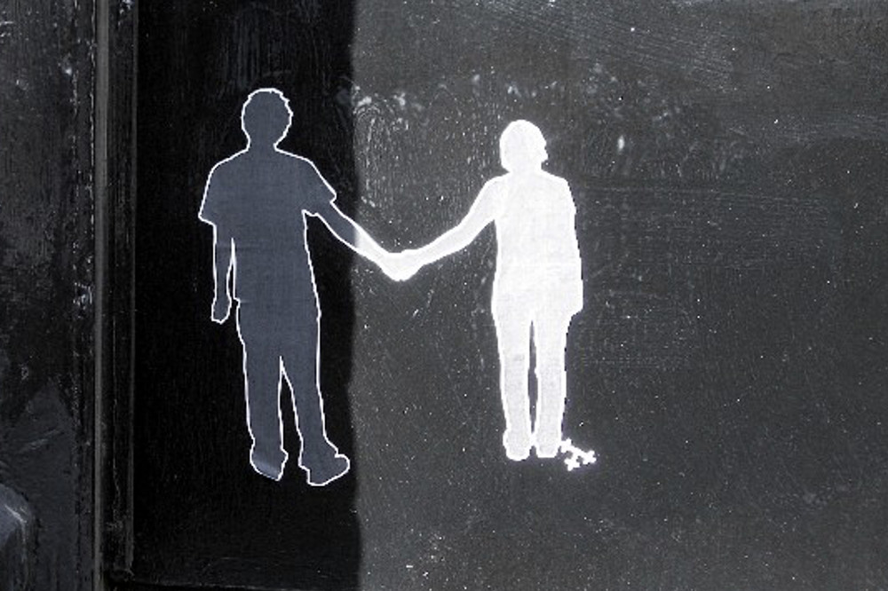 Street art of two figures holding hands