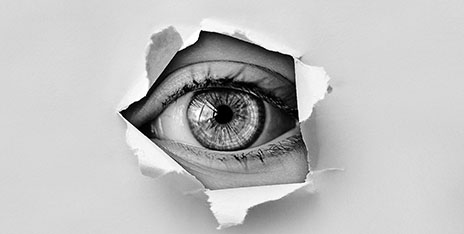 eye behind torn paper