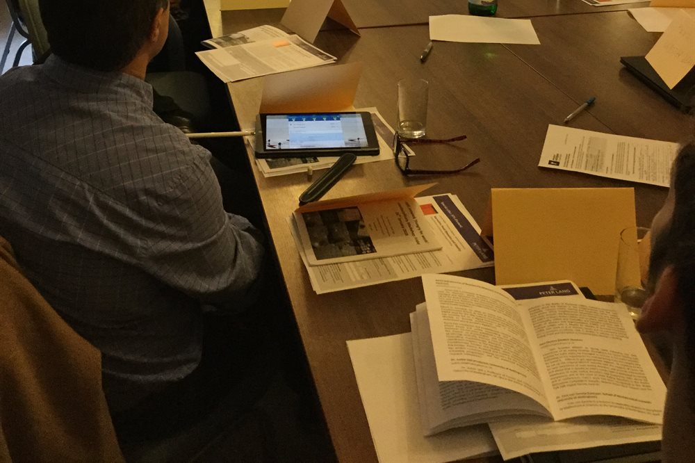Publications and papers open on a table during meeting