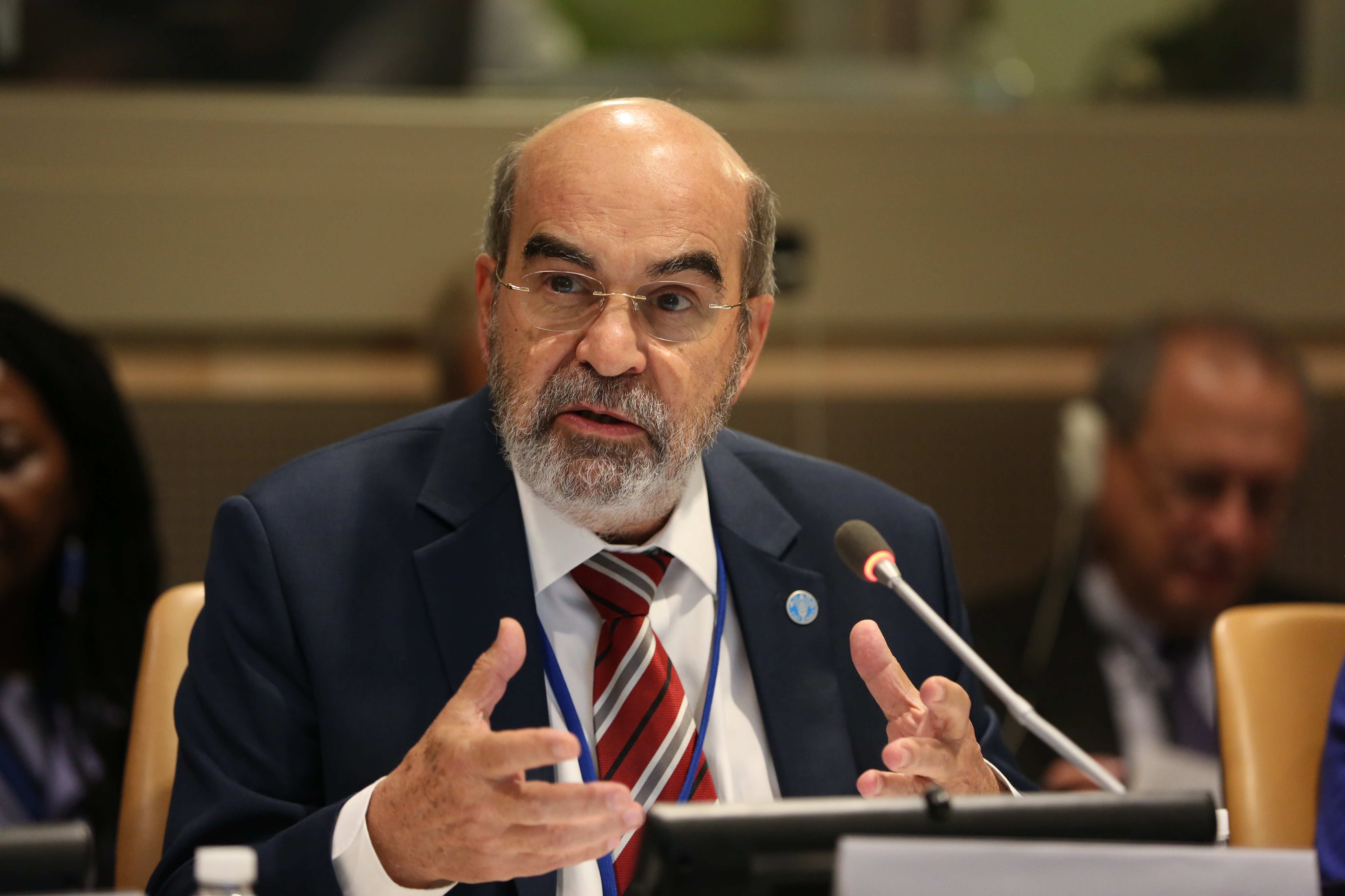 Portrait picture of Prof Graziano da Silva talking. He wears a suit with an FAO badge on the lapel.