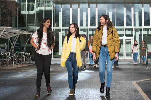 Three female students walking and chatting