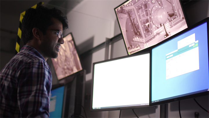 A researcher viewing turbine machinery operations on a set of computer monitors