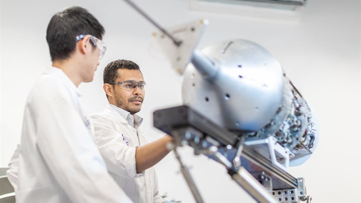 Engineering researchers examining an aeroplane component