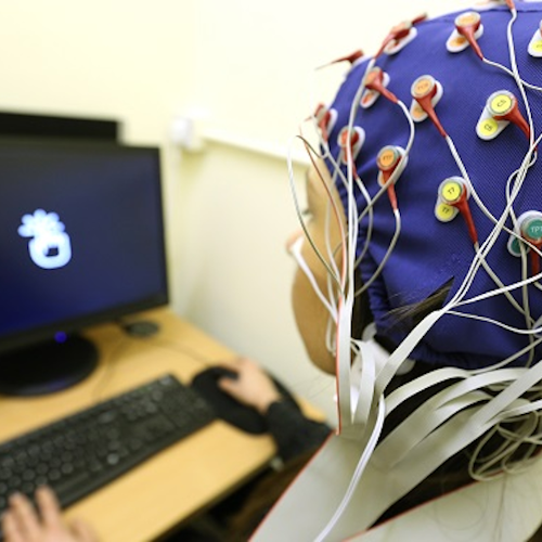 Student wearing cap to measure brain activity when reading on screen