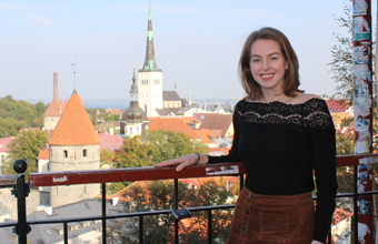 Kathryn Moore standing smiling on a balcony