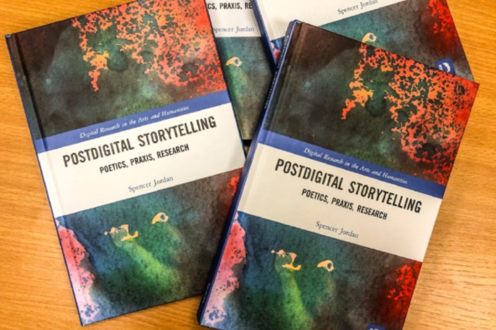 Four copies of postdigital storytelling overlaying each other on desk