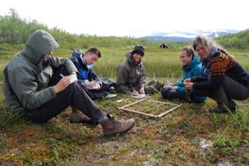 Environmental Biology students sat down on the grass on a field course abroad