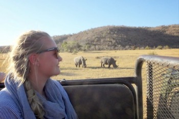 Penny Banham, BSc Animal Science student on Operation Wallacea on the Welgevonden Private Game Reserve in South Africa with rhinos in the background