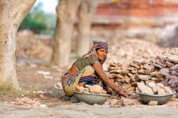 Indian woman worker collecting stones in India