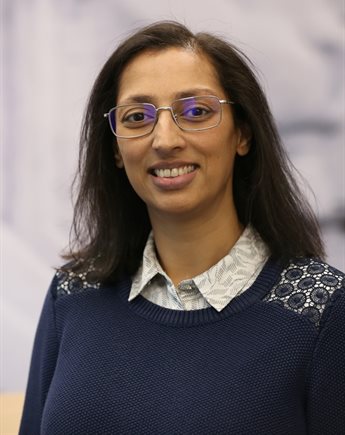 Profile photo of Avni Sondagar. She wears a shirt and jumper and smiles at the camera.