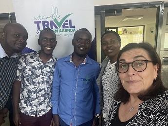 Photo of Job Odihambo, Dominic Wanjiru, Michael Mugendi, Pamella Ondiek and Marina Novelli in front of a wall saying Sustainable Travel and Tourism Agenda.