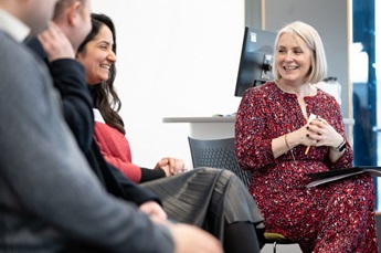 Sunny Sunshine sits next to Dr Hannah Noke, from the YES programme, and two other participants who are slightly off camera. They all sit in a panel arrangement and Sunny and Hannah are shown laughing