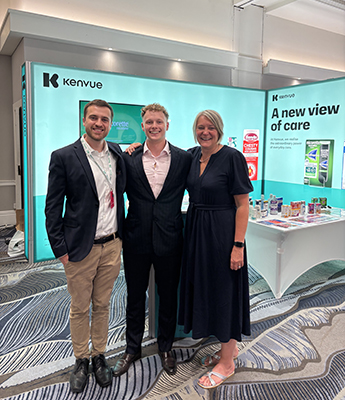 Photo of Guy Kitson stood with Joe Economos, Customer Development Manager from Kenvue, on his left and Jemma Price, Senior Customer Development Manager from Kenvue, on his right. In the background is an event stand with the company name Kanvue written on 